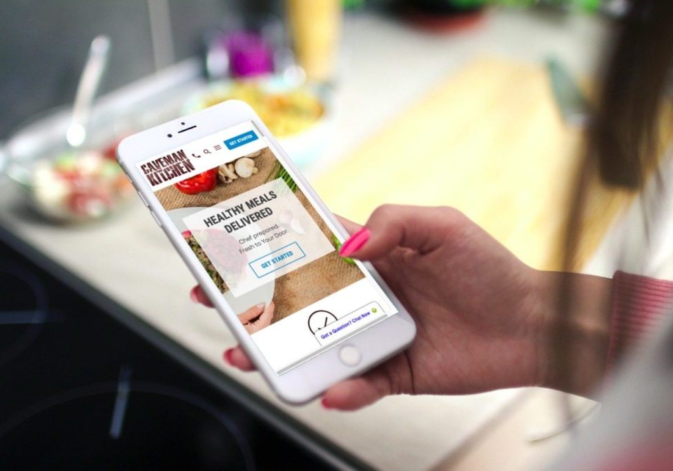 Caveman Kitchen website mockup on iPhone